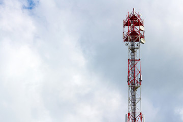 Telecommunication tower on the background of a cloudy sky with copyspace
