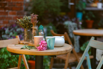 coffee mug at the exit of the cafe . Coffee on the street, on the steps of the terrace at the entrance to the cafe .