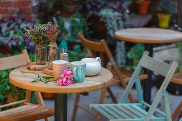 coffee mug at the exit of the cafe . Coffee on the street, on the steps of the terrace at the entrance to the cafe .
