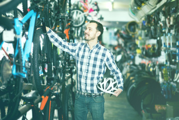 Man selects bicycle in sporting goods store