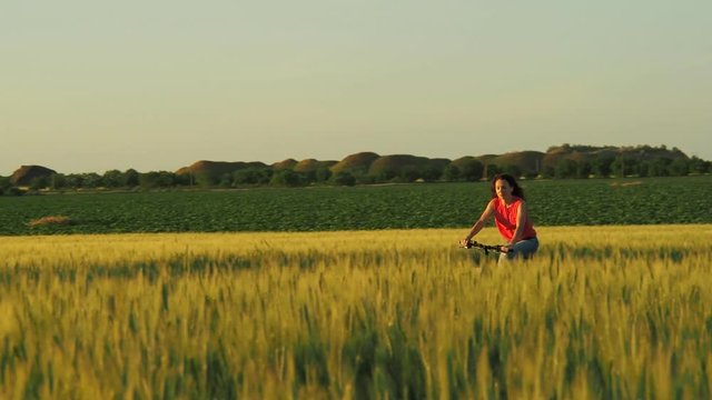 Girl riding a bike outdoors. Girl riding a bike in the field.