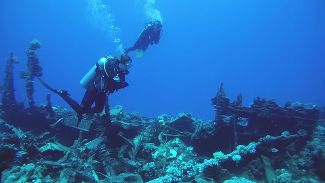 RED SEA, MARSA ALAM, EGYPT, AFRICA - JULE 2017: Scuba divers inspecting the shipwreck
