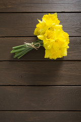 yellow daffodils on dark wooden surface