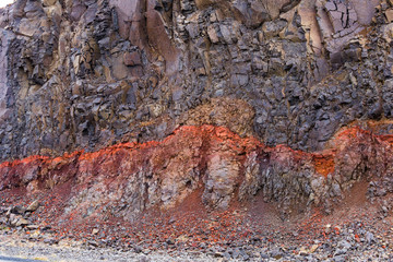 Closeup of red layer of clay between the basaltic layers in Westfjords, Iceland