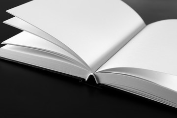 Open book with blank pages on black background