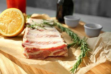 Raw ribs with ingredients on wooden board