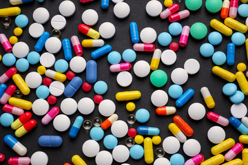 Different pills on dark background