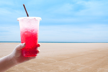 Women handle holding ice water italian soda red in plastic cup,Red, sweet  cool drink in the summer at the beach, during the holidays