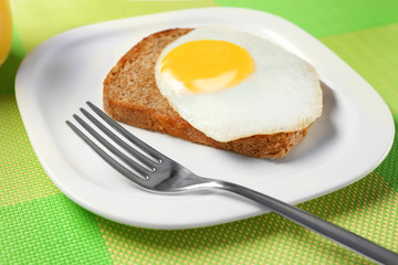 Delicious over easy egg with bread on kitchen table