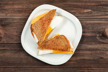 Delicious sandwiches with over easy egg and cheese on kitchen table