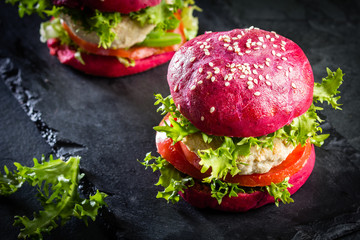 Colored purple beetroot buns and chicken burgers.