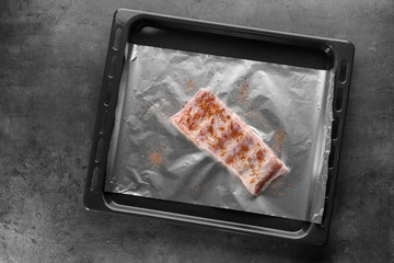 Baking tray with raw pork ribs on table