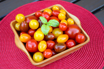 Different sorts of tomatoes served on a cerami dish. Healthy eating or vegetarian concept.