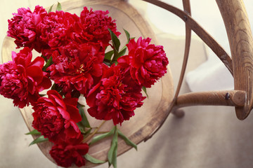 Top view of beautiful peonies on wooden chair