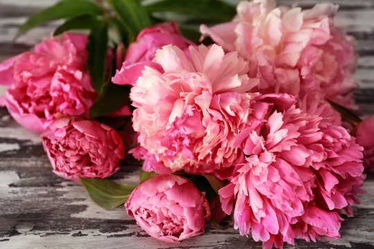 Beautiful bouquet of colorful peonies on wooden table