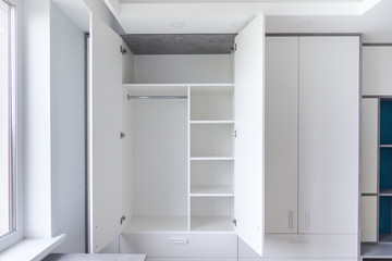 White empty closet for different clothes. A cupboard with shelves and hanger.  - obrazy, fototapety, plakaty