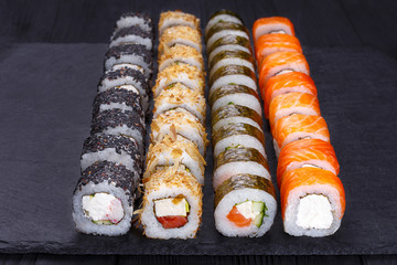 Restaurant menu, Japanese food art. Appetizing maki sushi set, served on black stone slate