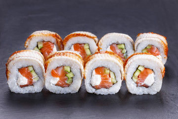 Appetizing Golden Dragon sushi rolls with smoked eel served on black stone table