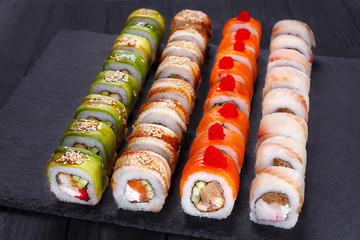 Restaurant menu, Japanese food art. Appetizing maki sushi set, served on black stone slate