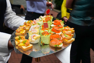 Waiter serving delicious snacks outdoors