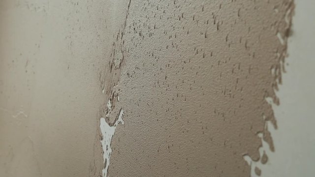 Closeup slow motion shot of builder applying plaster to a stud wall