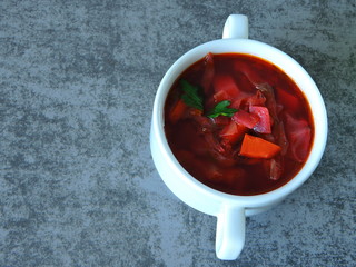 Beautiful red soup in a white dish. Ukrainian red borsch. Authentic food. Slavic mood.
