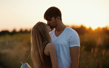 Romantic Couple at Sunset. Two people in love at sunset or sunrise. Man and woman on field
