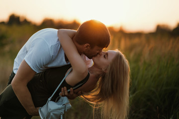 Romantic Couple at Sunset. Two people in love at sunset or sunrise. Man and woman on field