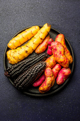 Peruvian raw ingredients for cooking black corn and sweet potatoes. Top view