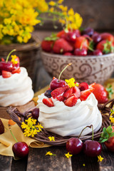 Delicious mini Pavlova meringue cake decorated with fresh berries