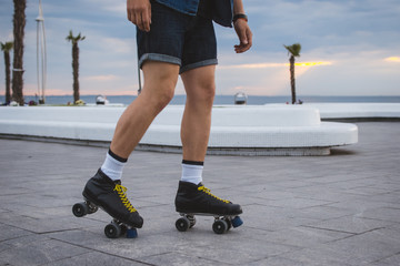 Young caucasian man roller skating with quad skates near the sea, close up - 164641442