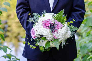 groom holding wedding bouquet