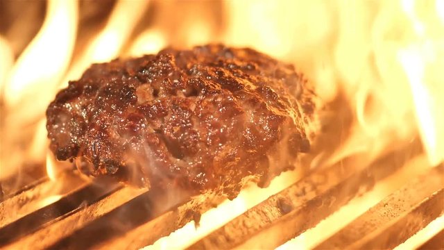 Tasty beef burger flipping on the grill HD