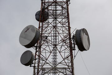 Telecommunication towers on cloudy sky