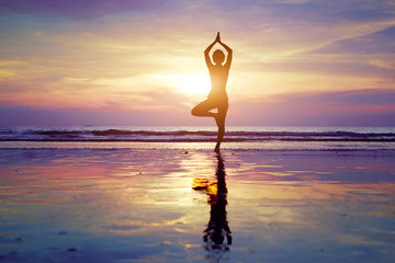 yoga on the beach, silhouette of woman
