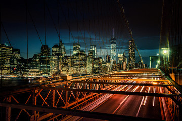 Cars speeding at sunset on Brooklyn Bridge, Manhattan. One of the most iconic bridges in the world,...
