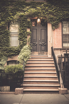 Ivy Covered Exterior Door On New York City Brownstone Apartment Building  With Vintage Tone