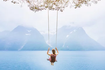 Zelfklevend Fotobehang Vrouwen droomconcept, mooie jonge vrouw op de schommel in fjord Noorwegen, inspirerend landschap