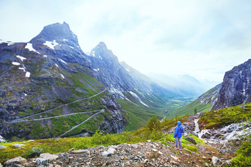Fototapeta na wymiar Trollstigen in Norway, tourist looking at mountain road in stunning beautiful landscape