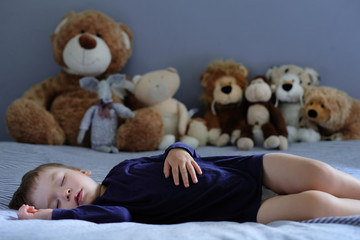 Cute sleeping baby with his teddy bears in the background. Portrait with a copy space.