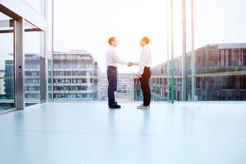 business cooperation concept, collaboration, two business people shaking hands in office interior