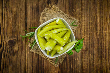 Green Chilis (filled with cheese) on wooden background (selective focus)