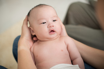 cute looking asian baby hugged by father