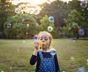 Kindergarten schoolgirl playing blowing bubbles fun