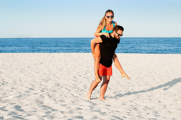 Happy young joyful couple together during summer holidays vacation on tropical beach.