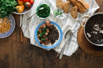 Plate with steak grilled and black quinoa on wooden table