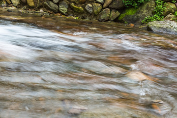 Stream Flowing Through Rocks in forest.
