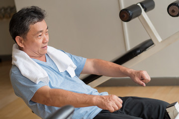 Obraz premium healthy, happy, smiling, positive senior well being asian man working out ab muscle in gym