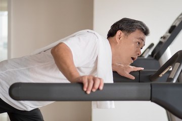 Fototapeta premium exhausted senior man in gym threadmill