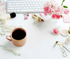 Flat lay, top view office feminine desk, female make up accessories, workspace with laptop, cup of coffee and bouquet roses.Beauty blog concept